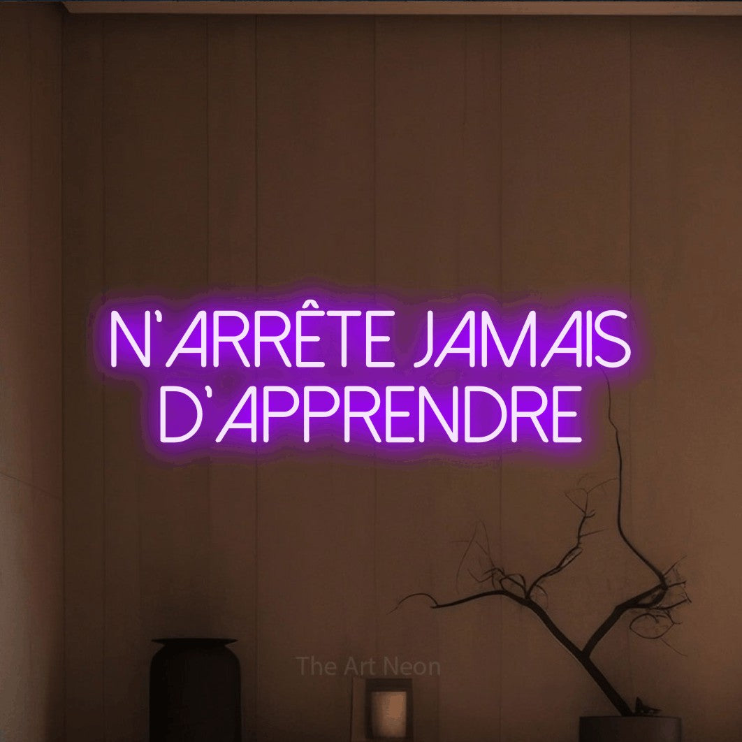 LED neon sign reading “N'arrête jamais d'apprendre”, arranged in 2 lines.