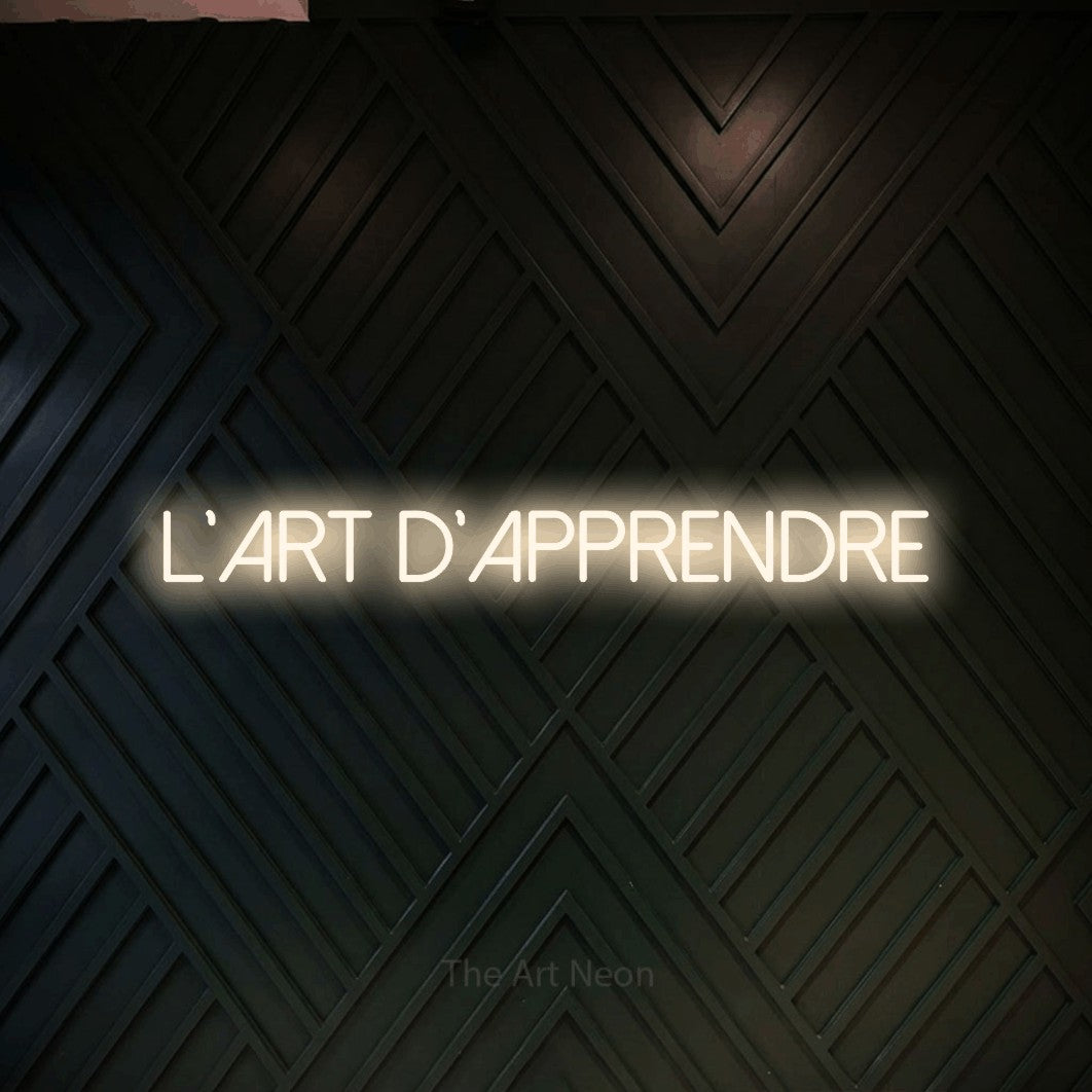 LED neon sign reading “L'art d'apprendre”, arranged in a single line.