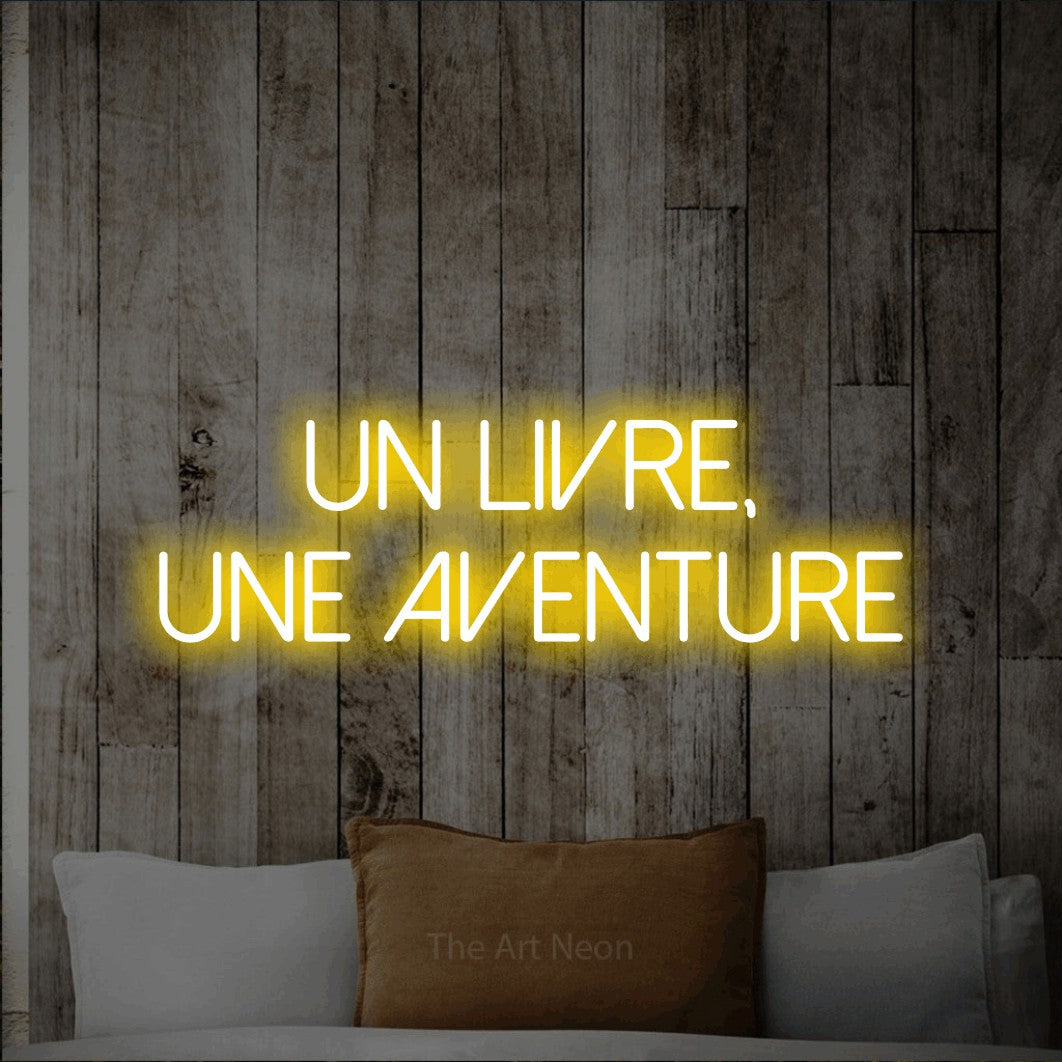 LED neon sign reading “un livre, une AVENTURE”, arranged in 2 lines.