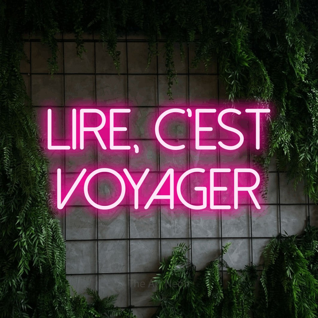 LED neon sign reading “Lire, c'est voyager”, arranged in 2 lines.