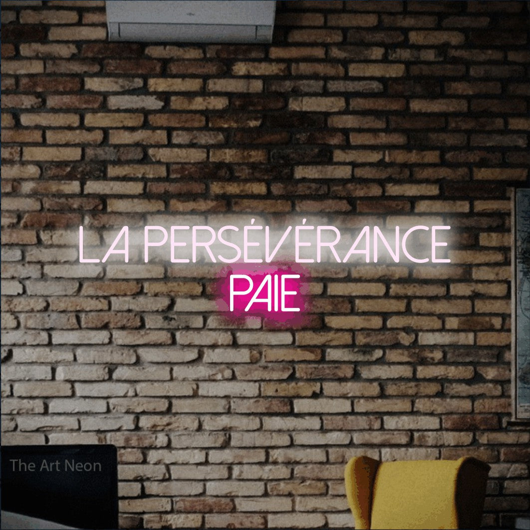 LED neon sign reading “LA PERSÉVÉRANCE PAIE”, arranged in 2 lines.
