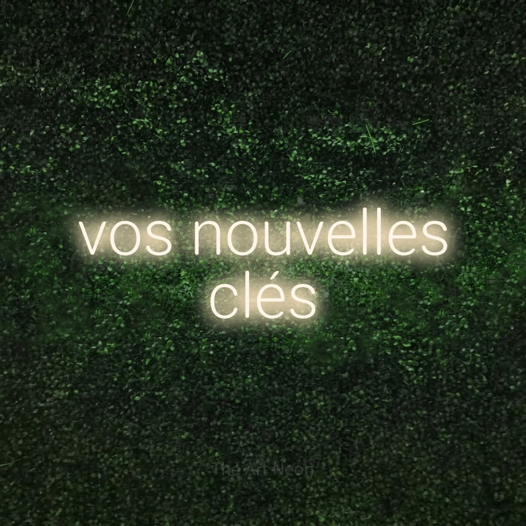 LED neon sign reading “vos nouvelles clés”, arranged in 2 lines.