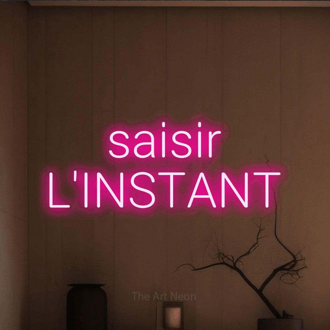 LED neon sign reading “saisir L'INSTANT”, arranged in 2 lines.