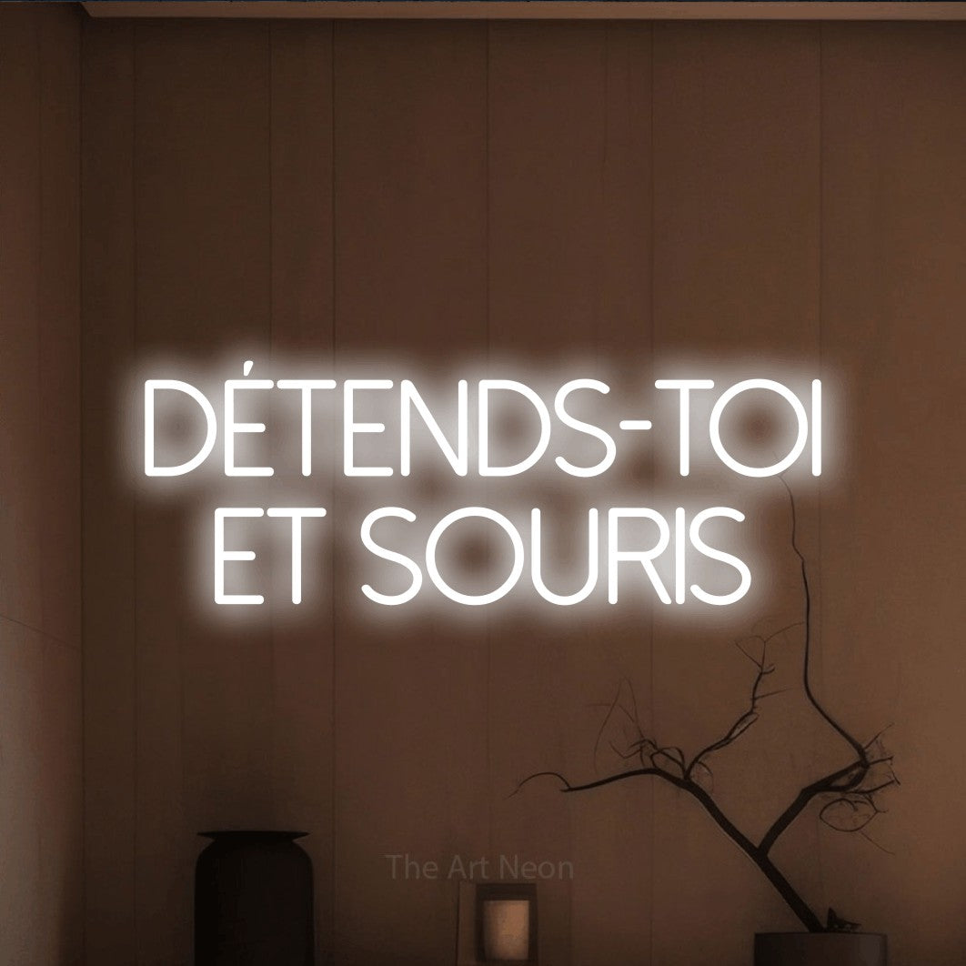 LED neon sign reading “Détends-toi et souris”, arranged in 2 lines.