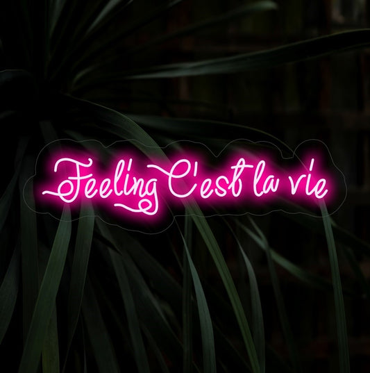 "Feeling C'est La Vie Neon Sign" lights up with a carefree glow, ideal for spaces that embrace the playful attitude of living life to the fullest with a touch of French flair.