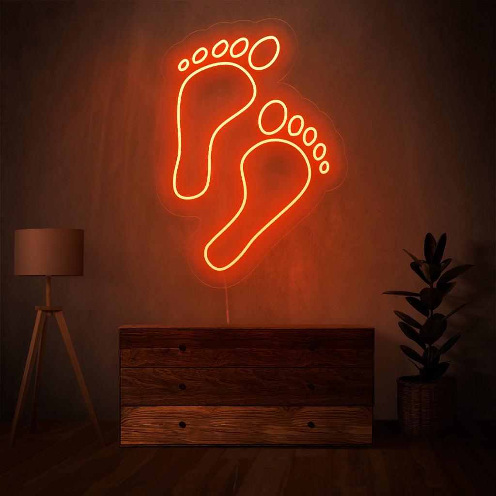"Footprints Neon Sign" - Leaving an impression of uniqueness, perfect for adventure-themed spaces and outdoor stores, celebrating the individual journey.