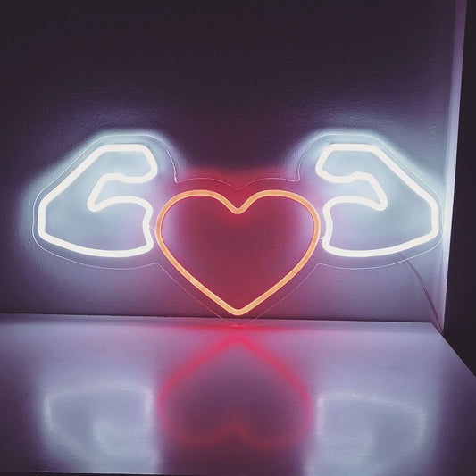 "Heart With Muscular Arms Neon Sign" - Exuding a playful and humorous vibe, perfect for fitness studios, gyms, or any space that wants to infuse energy and fun into the environment.