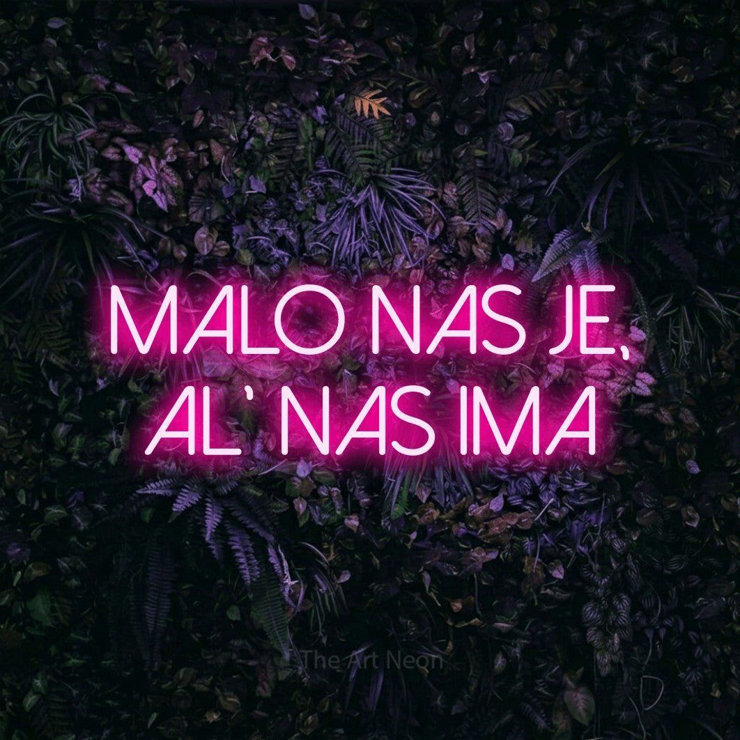 LED neon sign reading “MALO nas je, al' nas ima”, arranged in two lines.