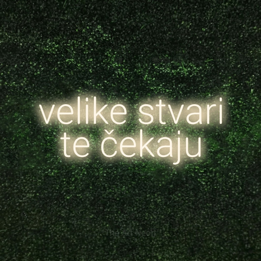 LED neon sign reading “velike stvari te čekaju”, arranged in two lines.