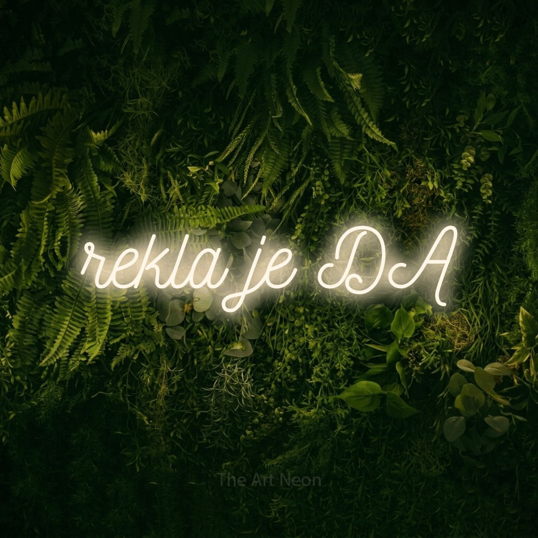 LED neon sign reading “rekla je DA”, arranged in a single line.