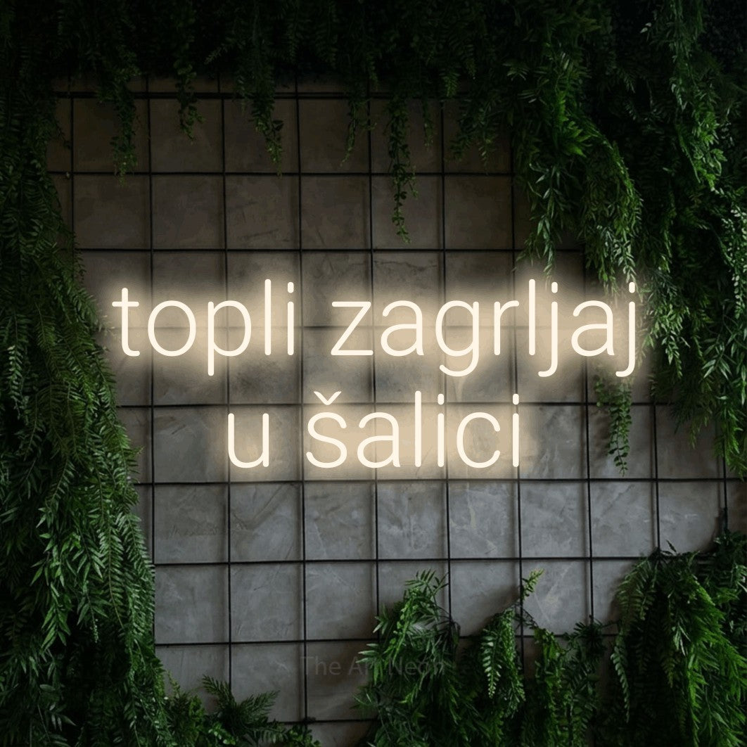 LED neon sign reading “topli zagrljaj u šalici”, arranged in two lines.