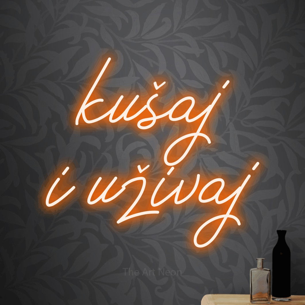 LED neon sign reading “kušaj i uživaj”, arranged in two lines.