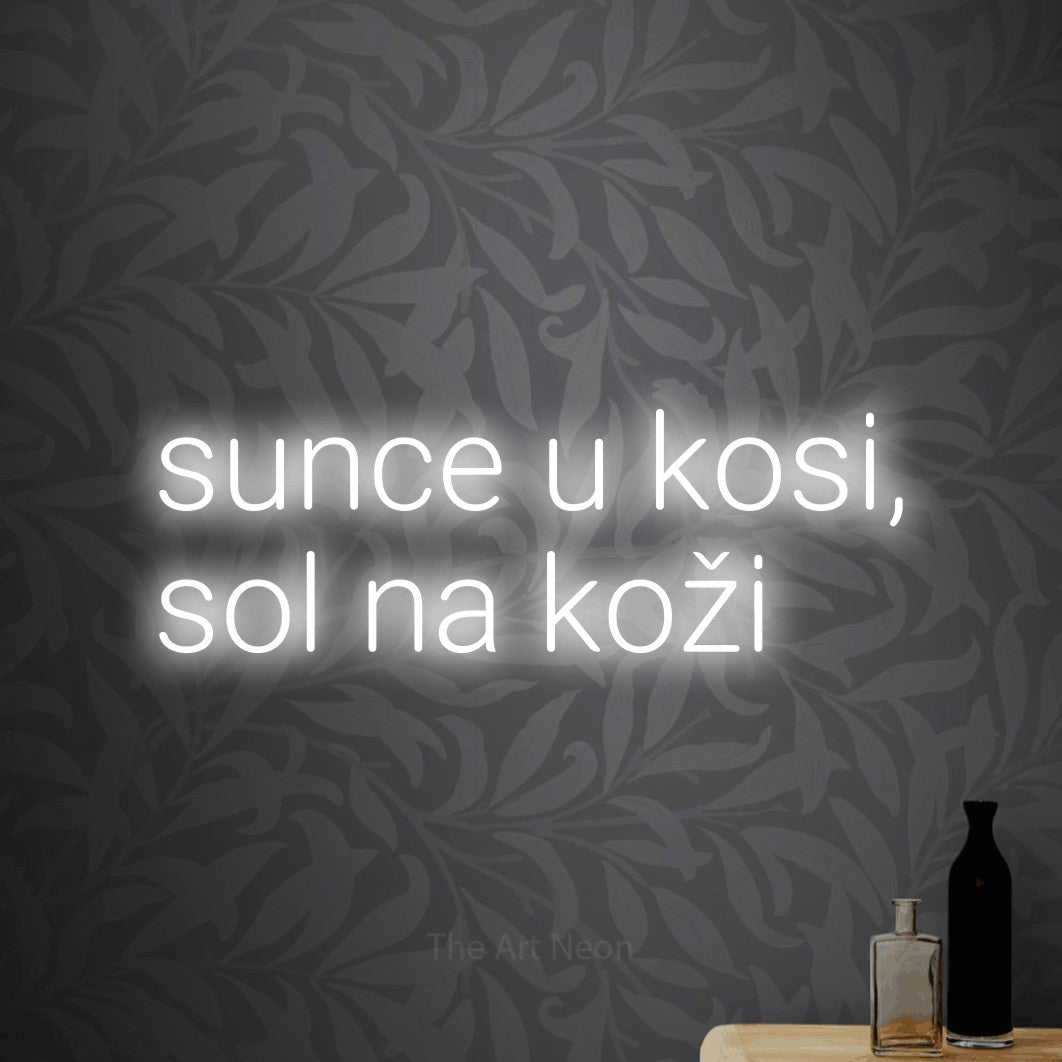 LED neon sign reading “sunce u kosi, sol na koži”, arranged in two lines.