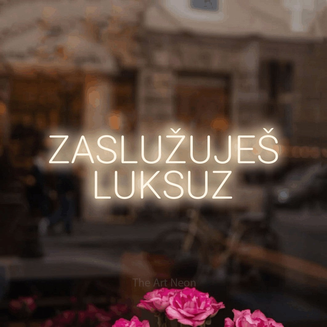 LED neon sign reading “ZASLUŽUJEŠ LUKSUZ”, arranged in two lines.
