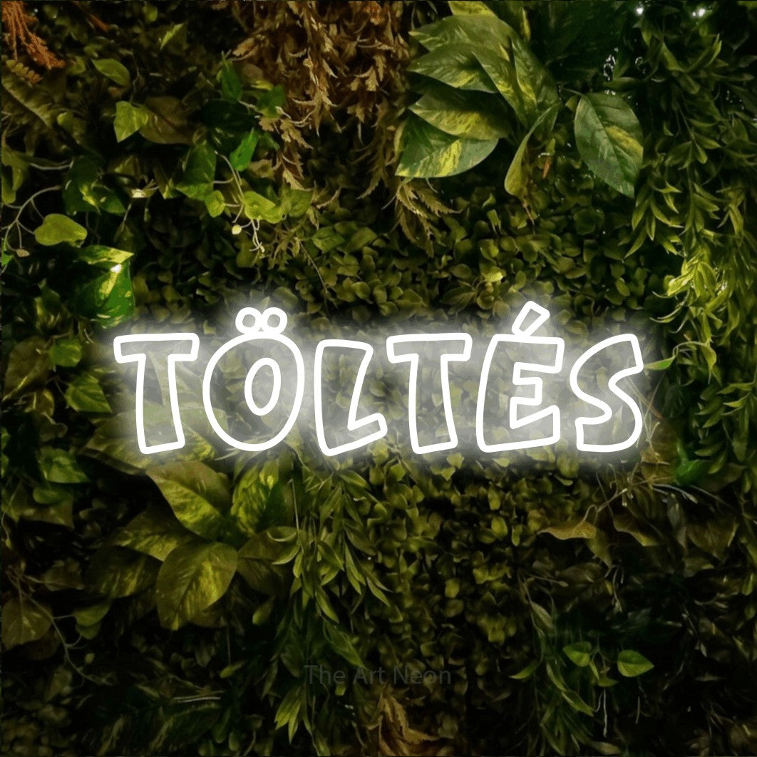 LED neon sign reading “TÖLTÉS”, arranged in a single line.