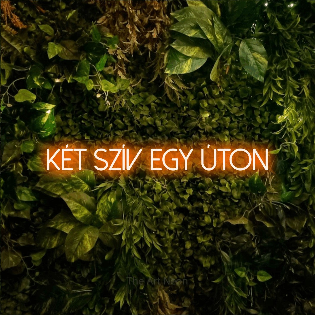 LED neon sign reading “két szív egy úton”, arranged in a single line.
