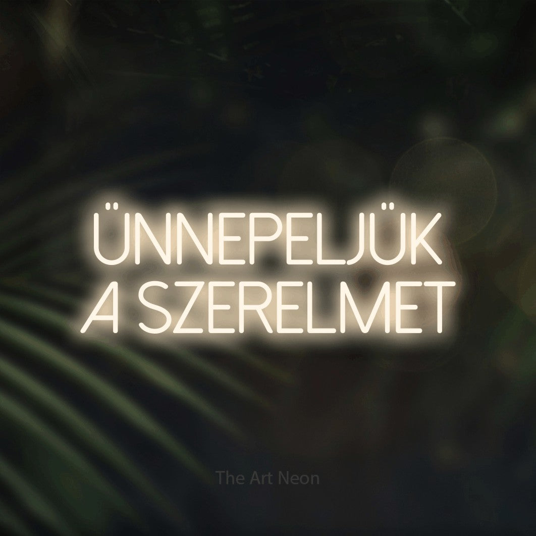 LED neon sign reading “ÜNNEPELJÜK A SZERELMET”, arranged in two lines.