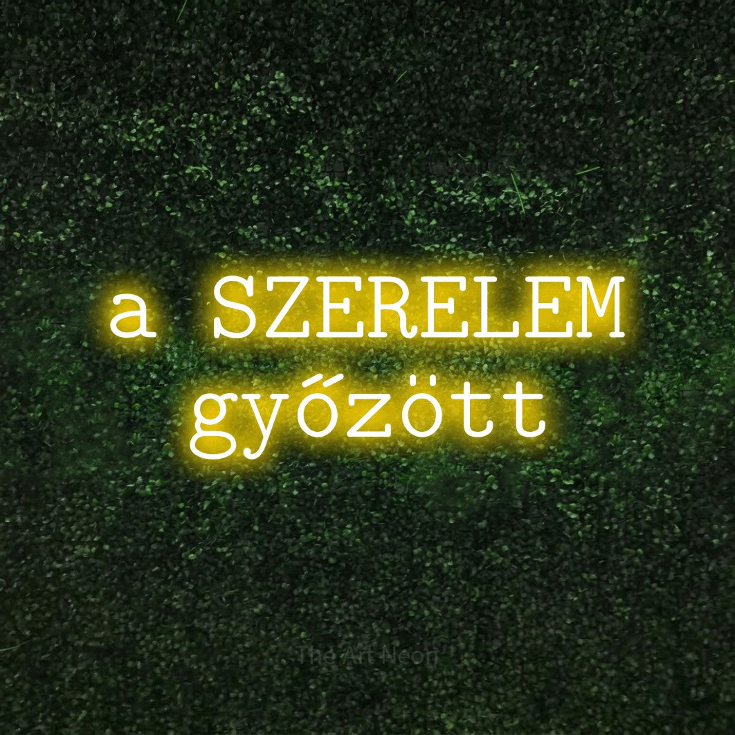LED neon sign reading “a SZERELEM győzött”, arranged in two lines.