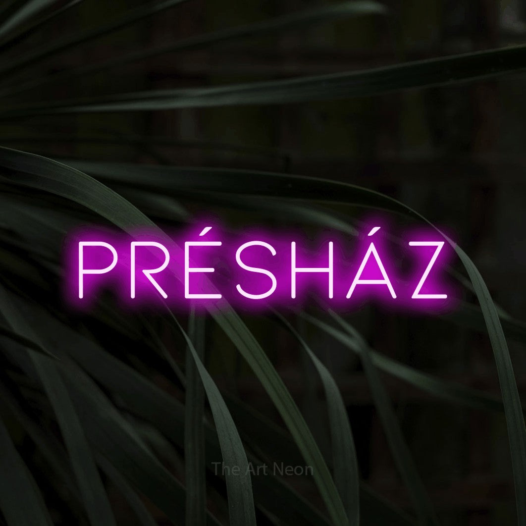 LED neon sign reading “PRÉSHÁZ”, arranged in a single line.