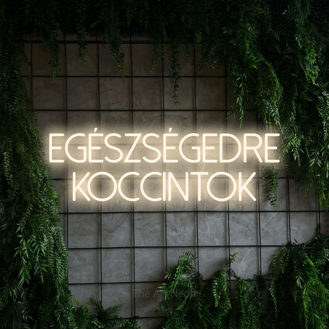 LED neon sign reading “EGÉSZSÉGEDRE KOCCINTOK”, arranged in two lines.