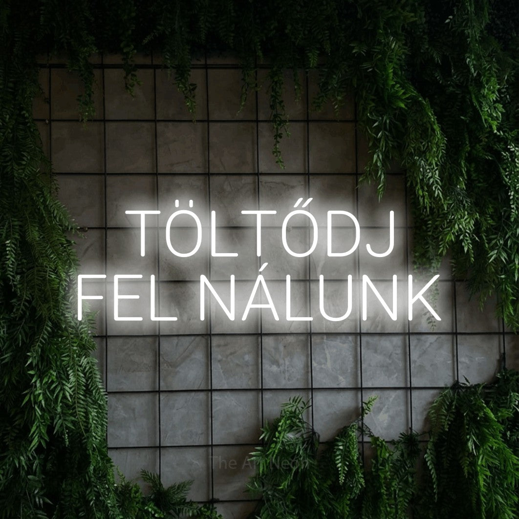 LED neon sign reading “TÖLTŐDJ FEL NÁLUNK”, arranged in two lines.