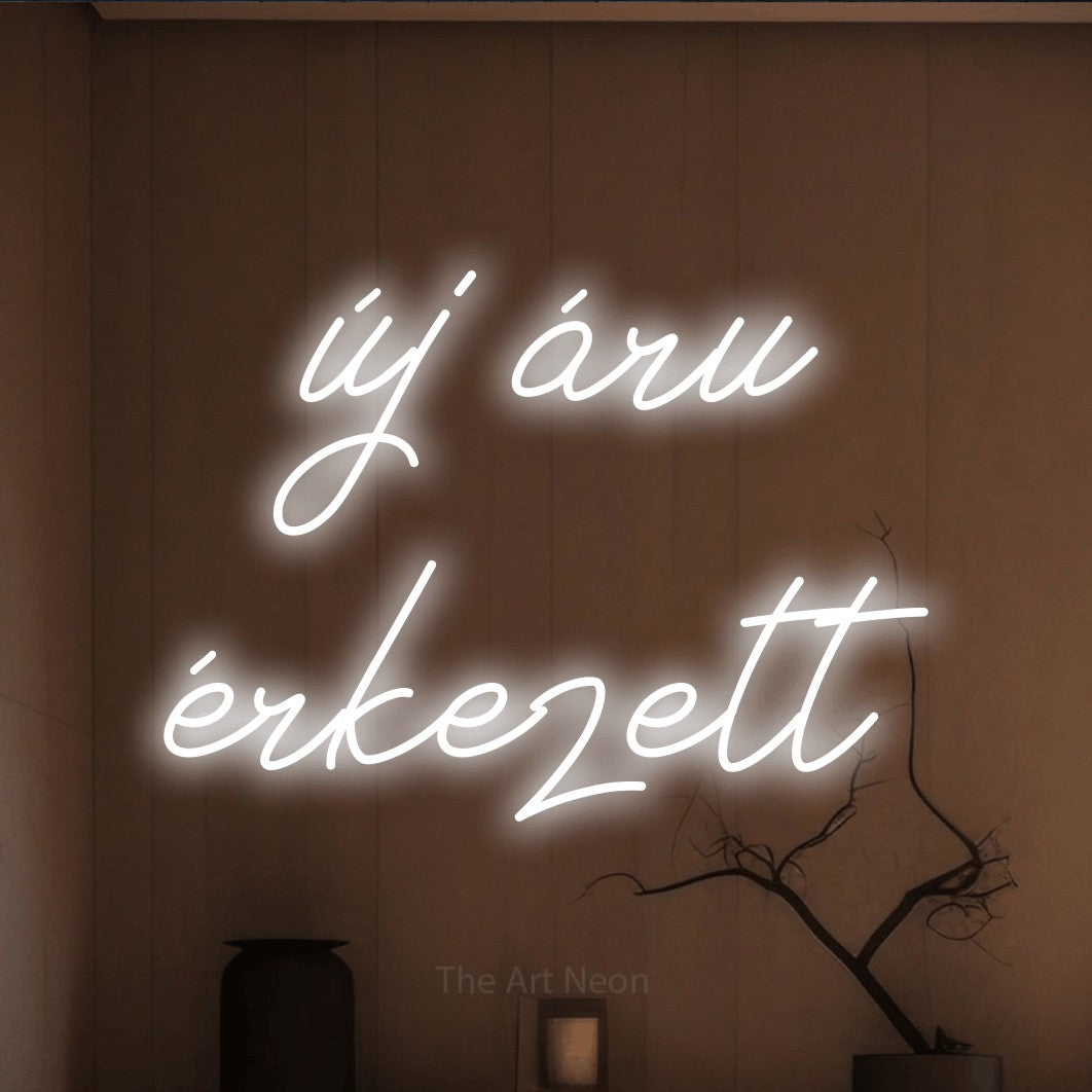 LED neon sign reading “új áru érkezett”, arranged in two lines.