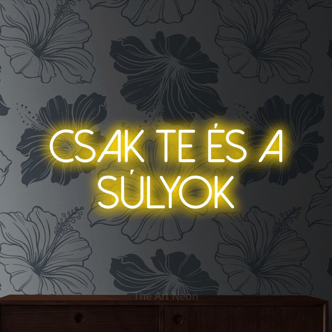LED neon sign reading “csak te és a SÚLYOK”, arranged in two lines.