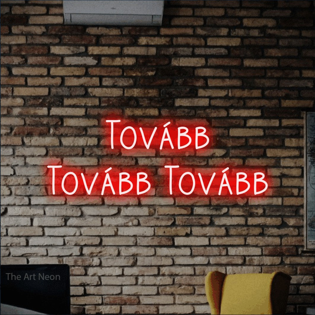 LED neon sign reading “Tovább Tovább Tovább”, arranged in two lines.