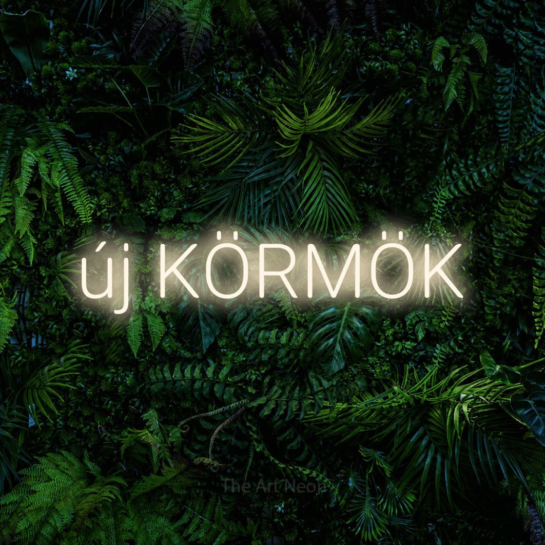 LED neon sign reading “új KÖRMÖK”, arranged in a single line.
