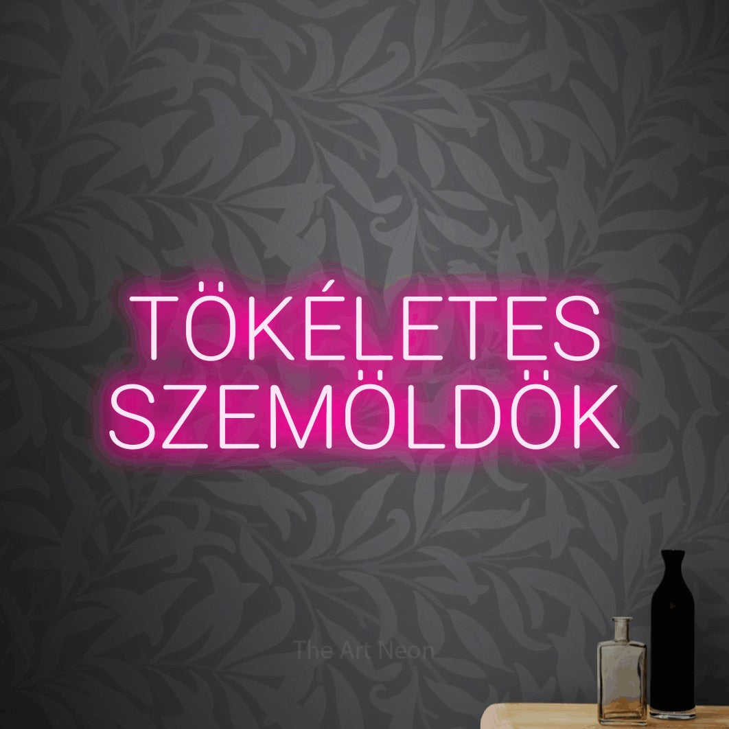 LED neon sign reading “TÖKÉLETES SZEMÖLDÖK”, arranged in two lines.