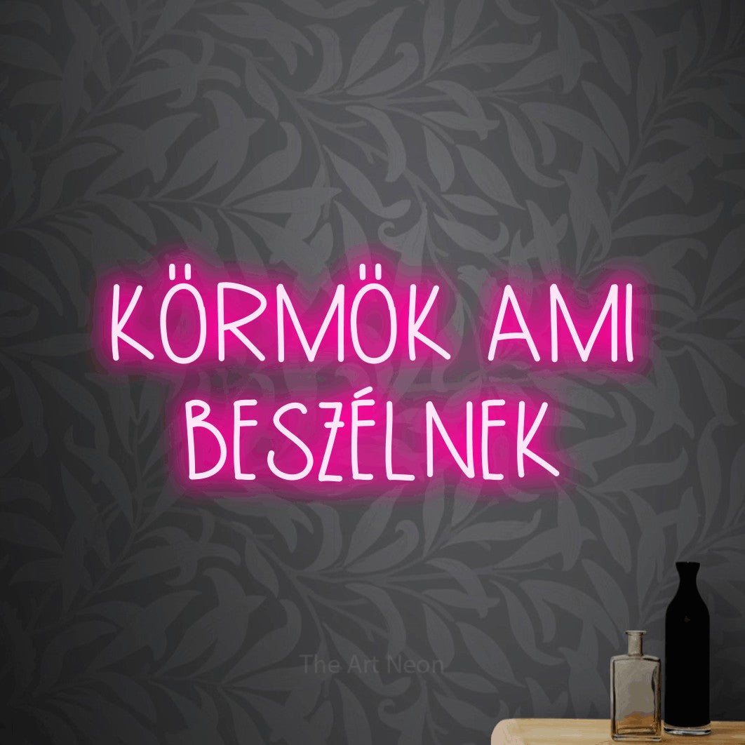 LED neon sign reading “KÖRMÖK AMI BESZÉLNEK”, arranged in two lines.