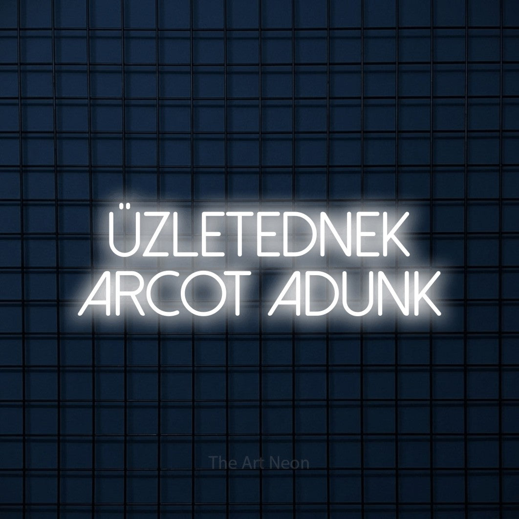LED neon sign reading “üzletednek arcot adunk”, arranged in two lines.