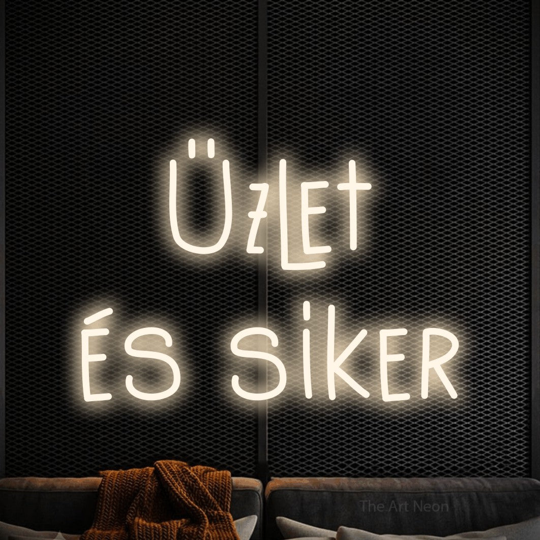 LED neon sign reading “Üzlet és siker”, arranged in two lines.