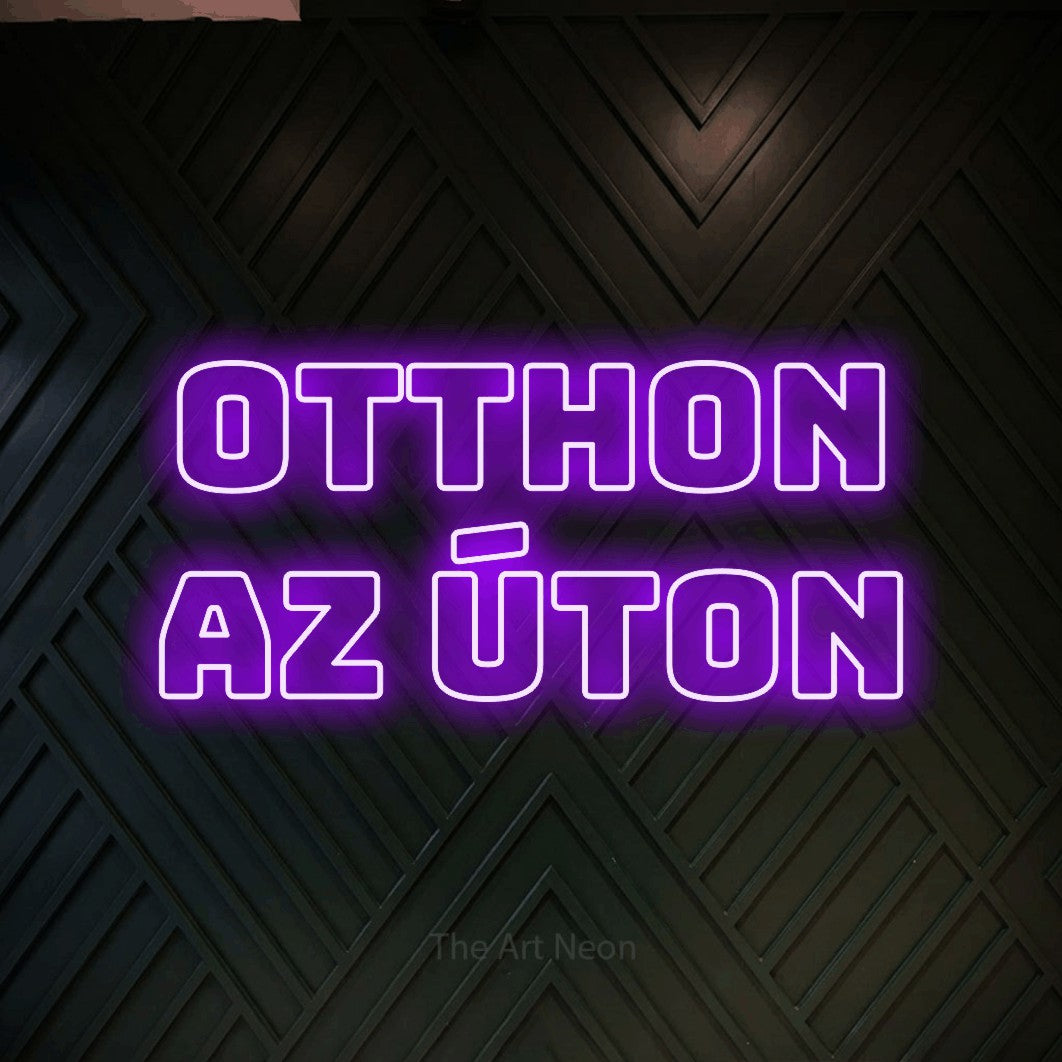 LED neon sign reading “otthon az úton”, arranged in two lines.
