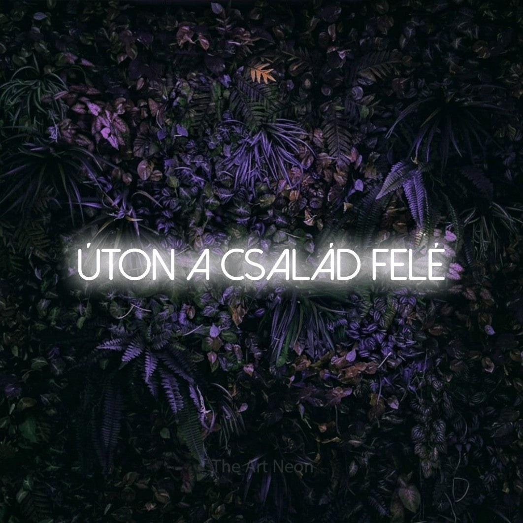 LED neon sign reading “úton a család felé”, arranged in a single line.