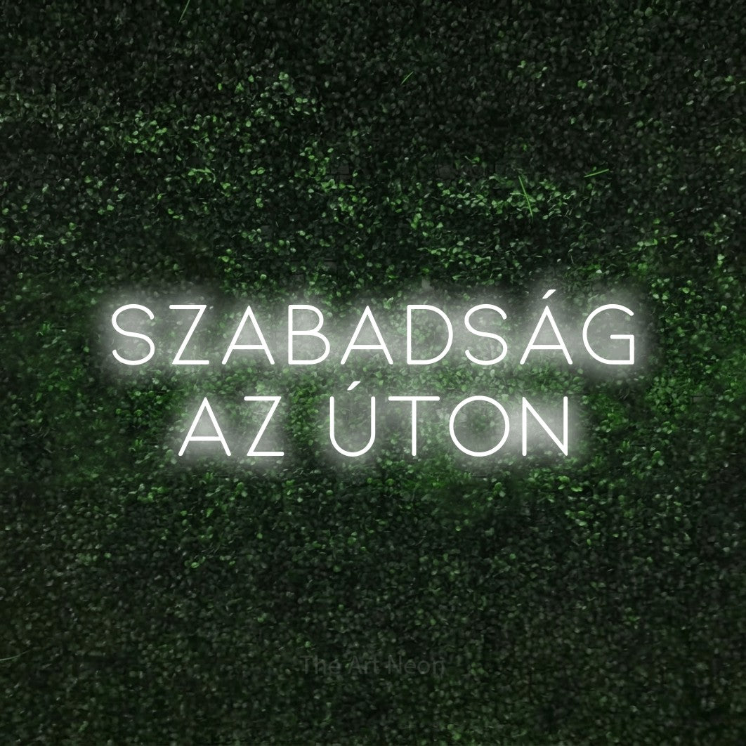 LED neon sign reading “Szabadság az úton”, arranged in two lines.