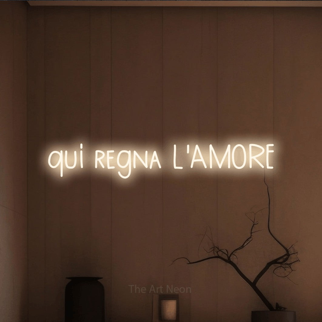 LED neon sign reading “qui regna L'AMORE”, arranged in a single line.