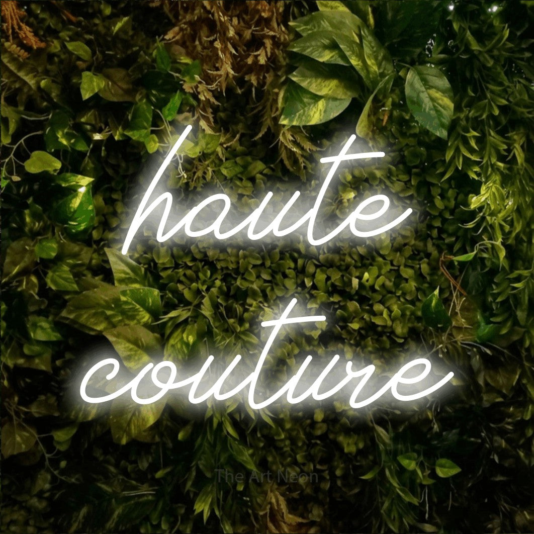 LED neon sign reading “haute couture”, arranged in 2 lines.