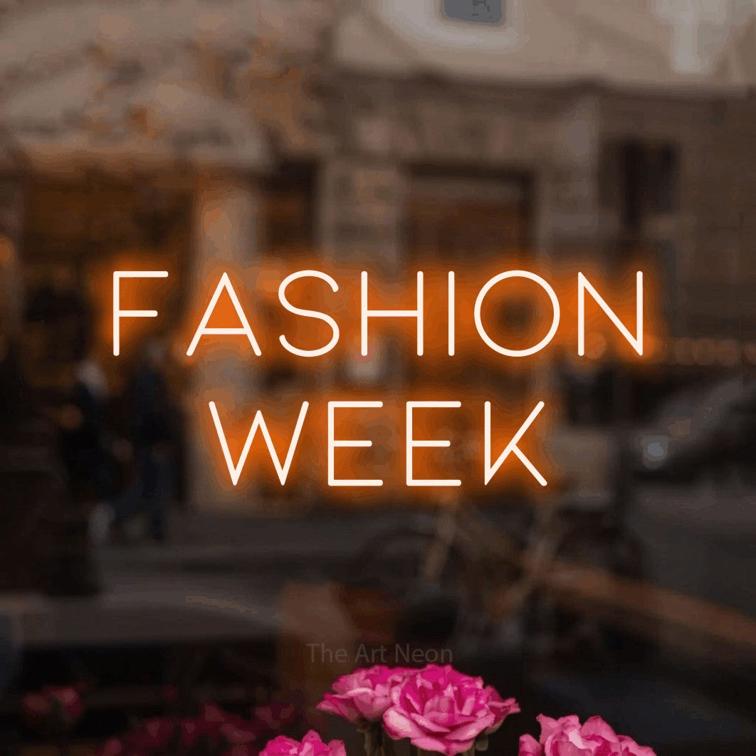 LED neon sign reading “Fashion Week”, arranged in 2 lines.