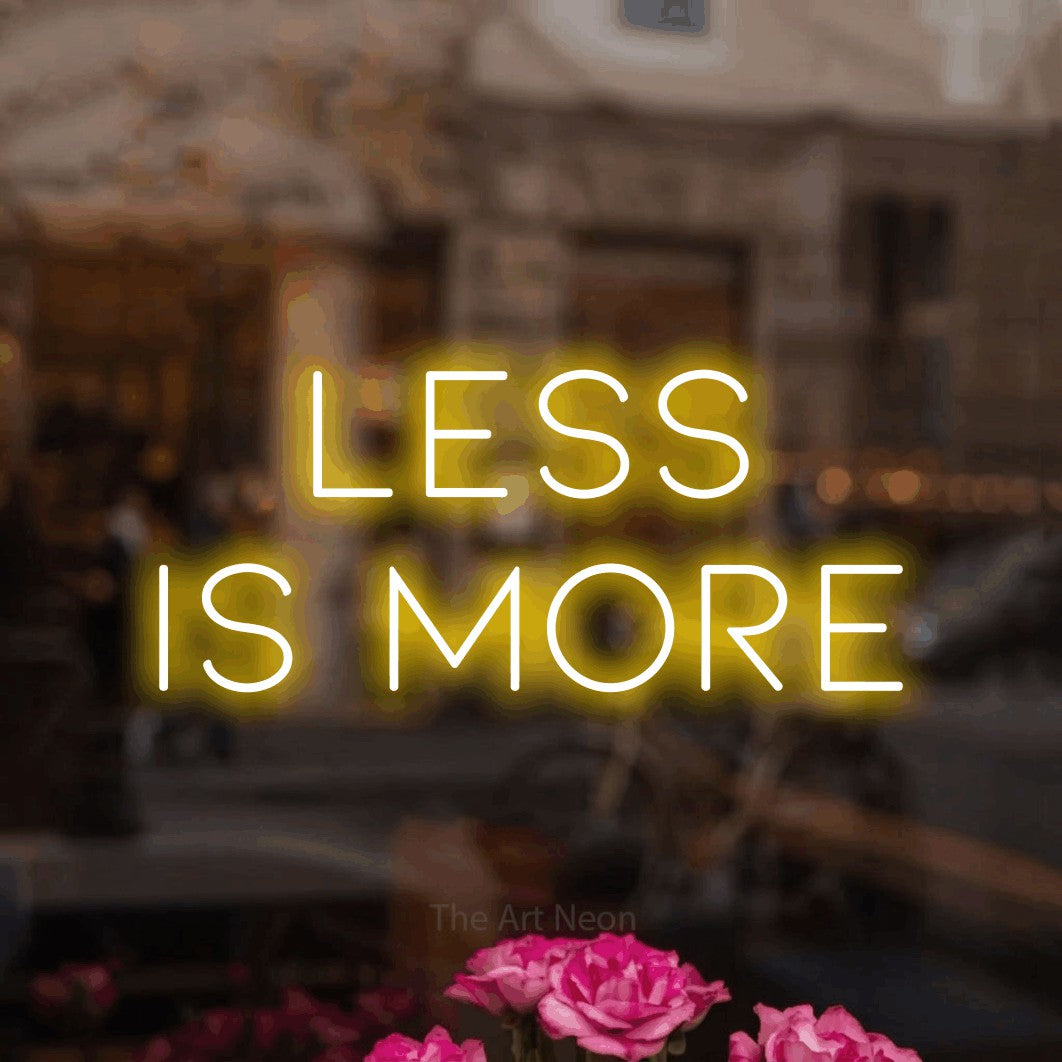 LED neon sign reading “Less is More”, arranged in 2 lines.