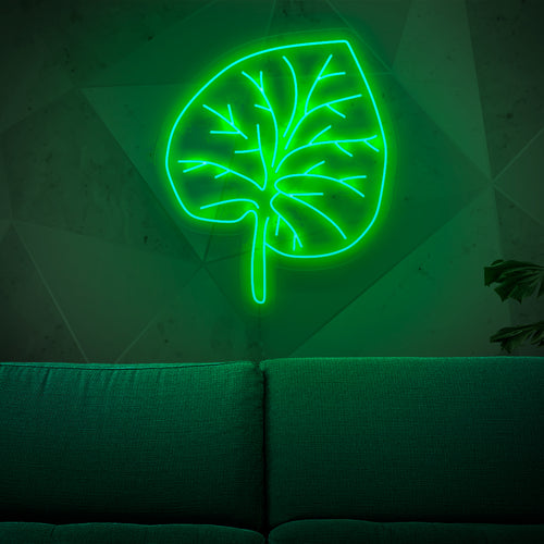 Un letrero de neón iluminado que presenta una hoja verde vibrante, que agrega un toque de belleza inspirada en la naturaleza y encanto orgánico a cualquier espacio.