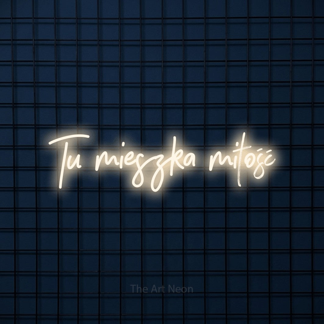 LED neon sign reading “Tu mieszka miłość”, arranged in a single line.