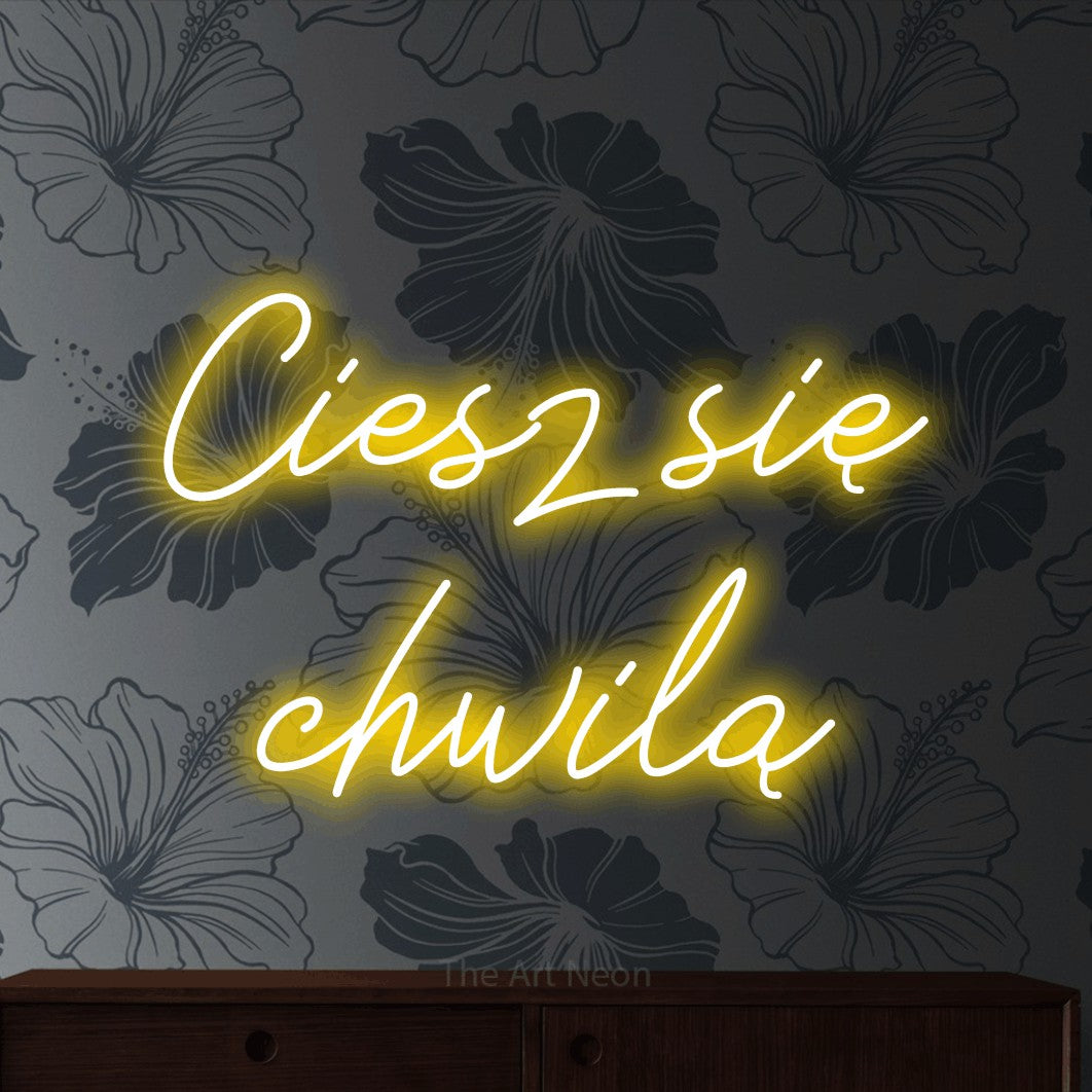 LED neon sign reading “Ciesz się chwilą”, arranged in two lines.