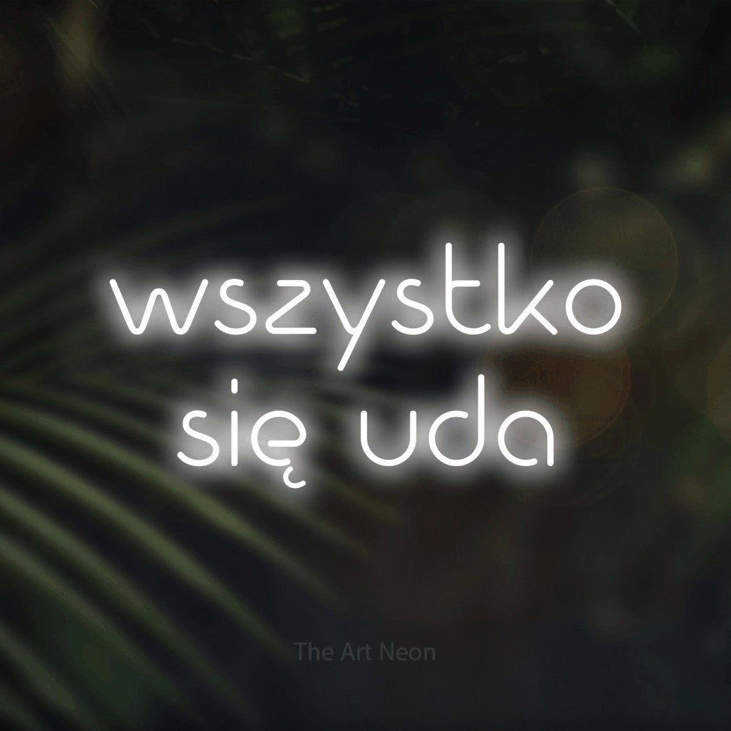 LED neon sign reading “wszystko się uda”, arranged in two lines.
