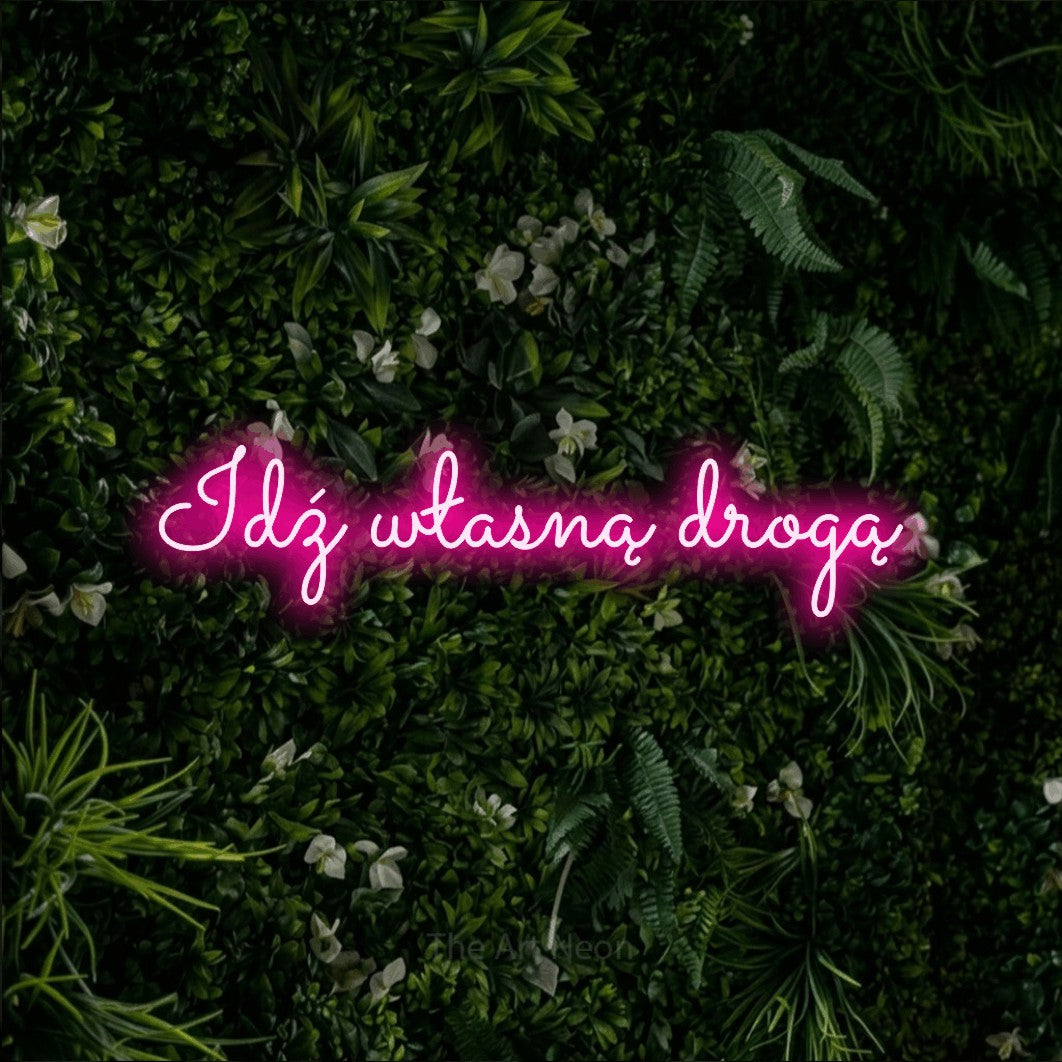 LED neon sign reading “Idź własną drogą”, arranged in a single line.