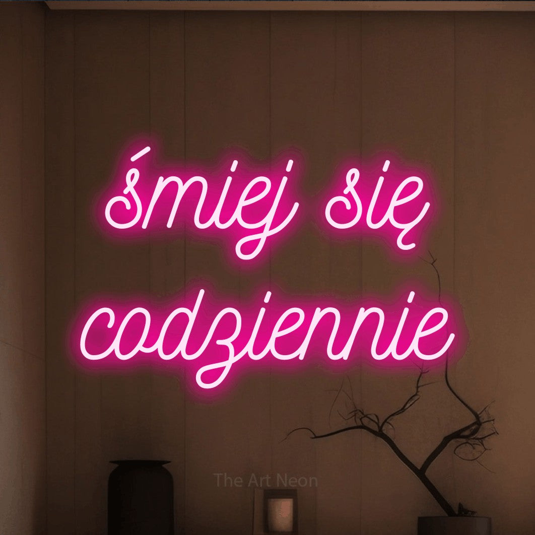 LED neon sign reading “śmiej się codziennie”, arranged in two lines.