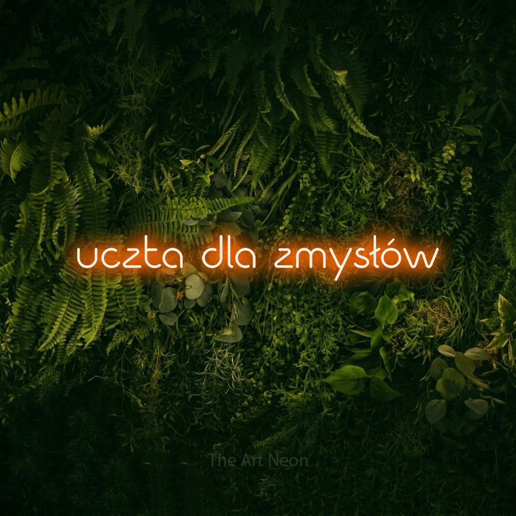 LED neon sign reading “uczta dla zmysłów”, arranged in a single line.