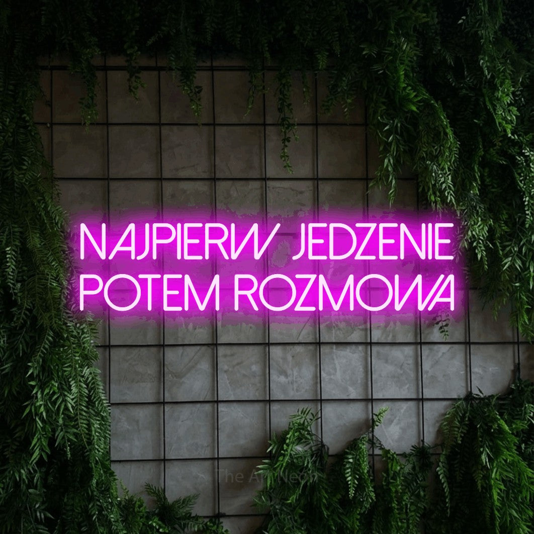 LED neon sign reading “najpierw jedzenie potem rozmowa”, arranged in two lines.