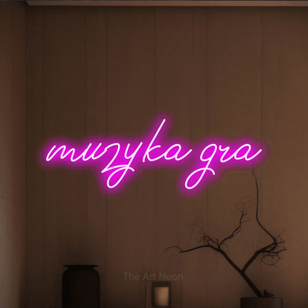 LED neon sign reading “muzyka gra”, arranged in a single line.