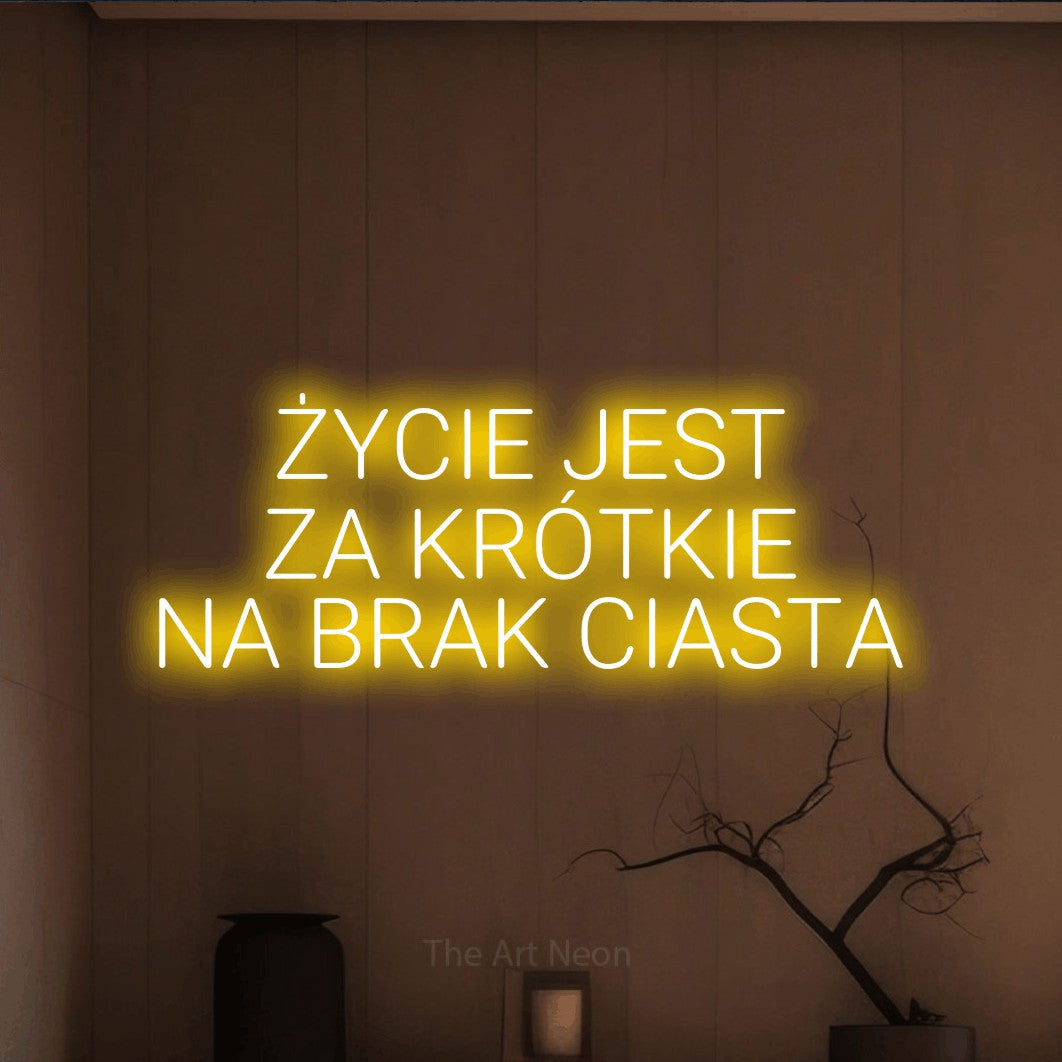 LED neon sign reading “ŻYCIE JEST ZA KRÓTKIE NA BRAK CIASTA”, arranged in three lines.